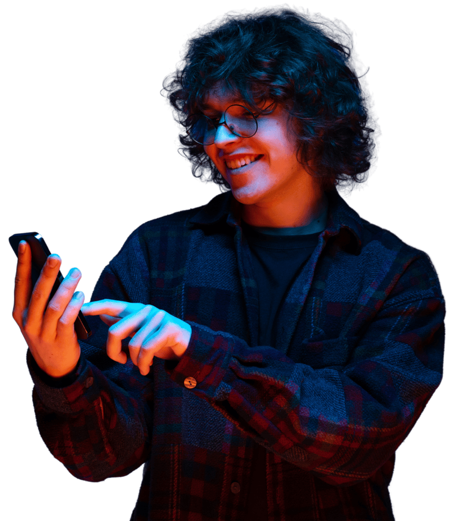 Person smiling while using a smartphone, standing against a blue background and interacting with the screen.